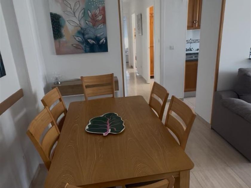 Comedor con mesa de madera y seis sillas, ordenado y listo para usar