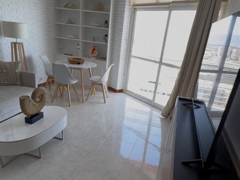 Salón luminoso con grandes ventanales y vistas abiertas al mar